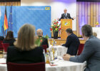 Blick durchs Publikum zur Bühne, Innenminister Joachim Herrmann bei Rede hinter Rednerpult, Publikum von hinten