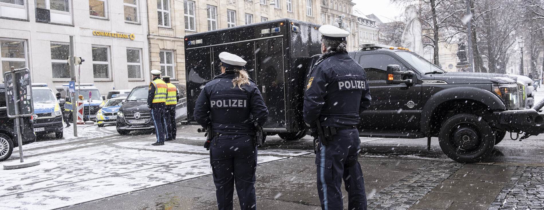 Mehrere Polizisten bei Sicherheitskontrolle von Fahrzeugen