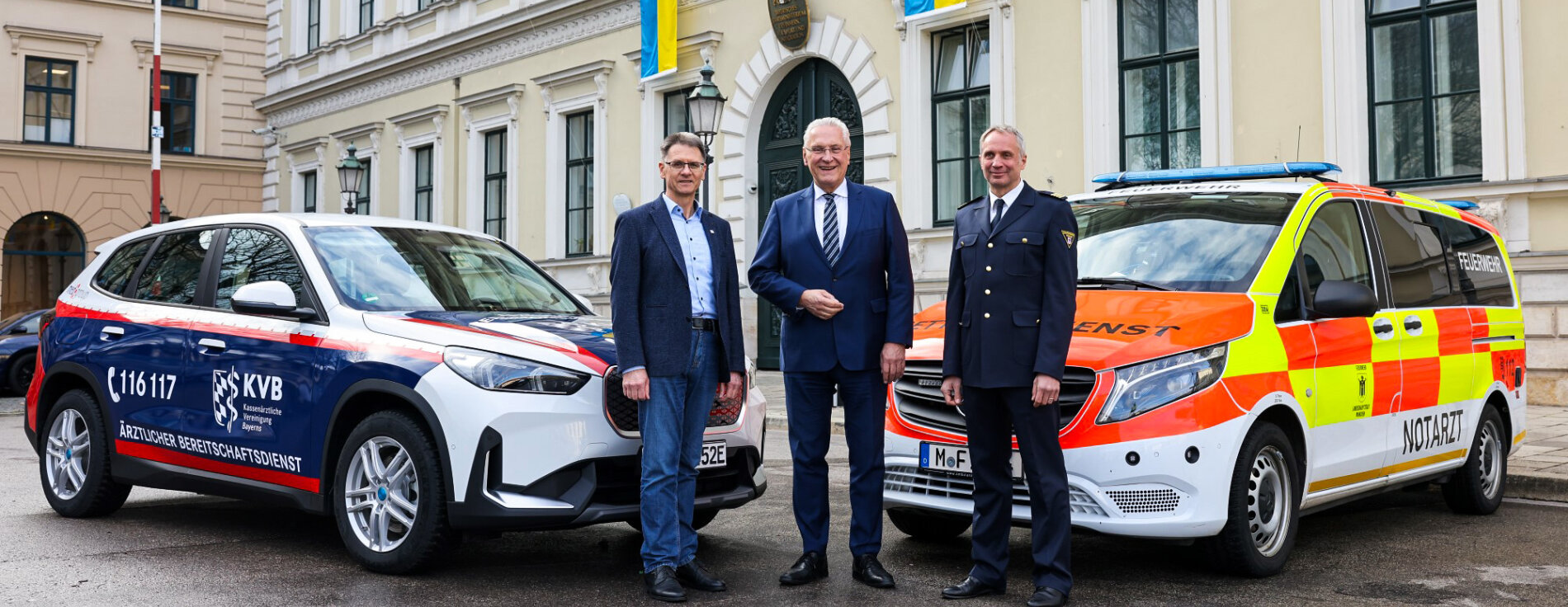 Innenminister Joachim Herrmann mit Dr. Christian Pfeiffer, Vorstandsvorsitzender der KVB und Florentin von Kaufmann, Vorsitzender des Verbandes der Bayerischen Leitstellenbetreiber zwischen Einsatzfahrzeugen des Bereitschaftsdienstes und des Rettungsdiensts