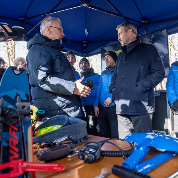 Auf dem Bild sind Innenminister Joachim Herrmann und Ministerpräsident Dr. Markus Söder mit Polizistinnen und Polizisten der Bayerischen Grenzpolizei und verschiedenen Ausrüstungsgegenständen zu sehen.