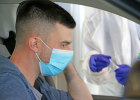 Blick auf eine Person mit Mundschutz im Auto
