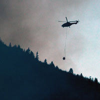 Ein Hubschrauber bekämpft den Waldbrand am Jochberg