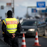 Ein Polizist beobachtet den Grenzverkehr an einer Autobahn