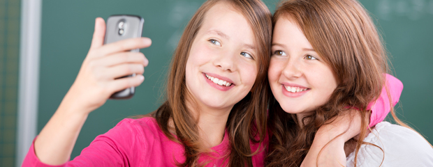 Zwei Mädchen fotografieren sich mit dem Handy