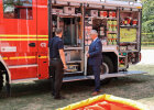 Herrmann lässt sich von jemandem am Feuerwehreinsatzfahrzeug etwas zeigen