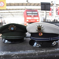 Polizeimützen der Bundes- und der Landespolizei im Hauptbahnhof München als Symbol für eine intensivere Zusammenarbeit zur Sicherheit im öffentlichen Personennahverkehr